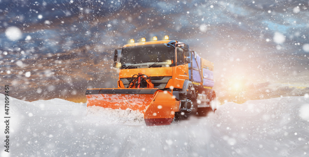A cleaning vehicle clears the snow from the street - onset of winter A cleaning vehicle clears the snow from the street - onset of winter