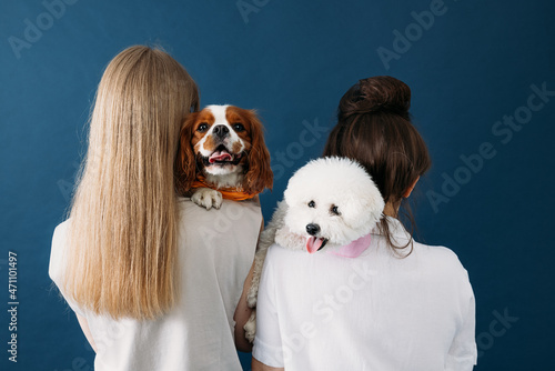 Canvas Print Back view of two women standing with their dogs