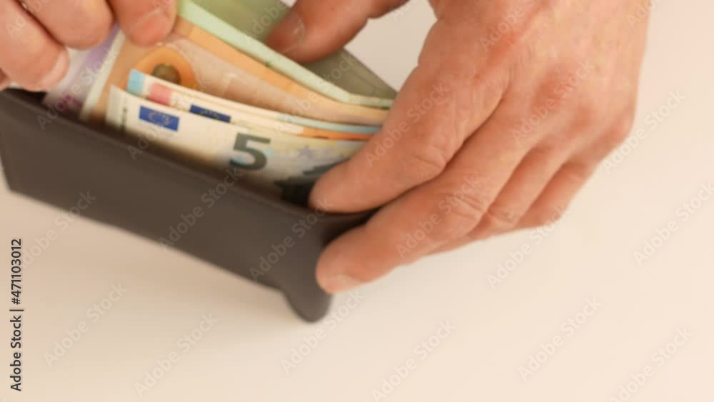 Close-up of a wallet in which bills of 5,10,20,50 euros. Man's hands count the euro cash out of the wallet. Payment for the purchase in cash in euros. Euro banknotes in a wallet. Selective focus Close-up of a wallet in which bills of 5,10,20,50 euros. Man's hands count the euro cash out of the wallet. Payment for the purchase in cash in euros. Euro banknotes in a wallet. Selective focus