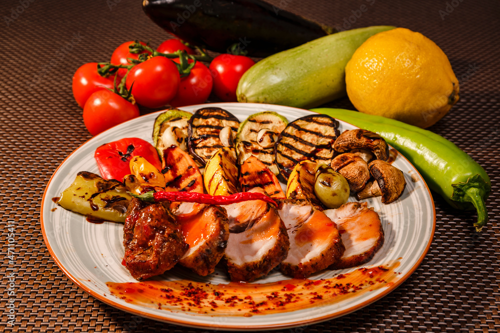 A plate full of tasty grilled meat served with sauce and pepper with lots of ingredients