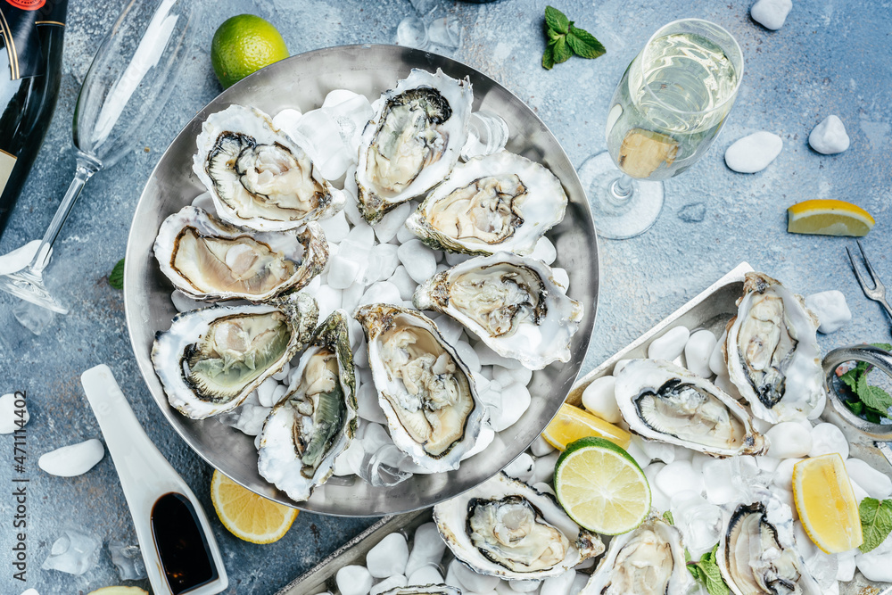 Fresh oysters with lemon and ice. Restaurant delicacy. oysters dish. Oyster dinner with champagne in restaurant Fresh oysters with lemon and ice. Restaurant delicacy. oysters dish. Oyster dinner with champagne in restaurant