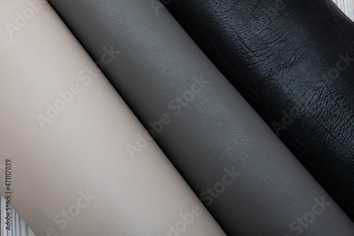 Colorful rolls of cow leather. Grey black palette. 