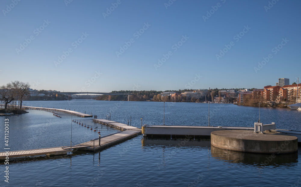 An empty marina with jetty and a concrete safety bollard in the bay between the districts Kungsholmen and Bromma. A sunny color full autumn day in Stockholm