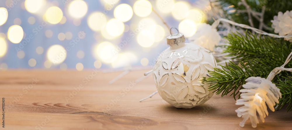 Christmas panoramic banner with christmas ball, fir branch, garland on a wooden table with defocused lights Christmas panoramic banner with christmas ball, fir branch, garland on a wooden table with defocused lights