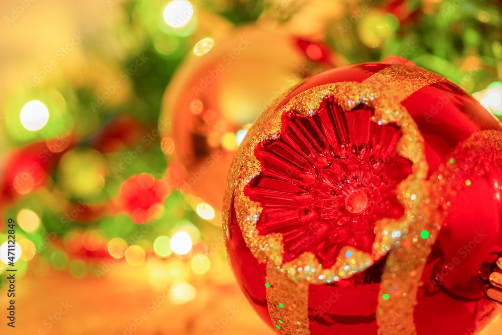 Soft focus  and sparkling Christmas ornaments surround a red and golden festive decoration