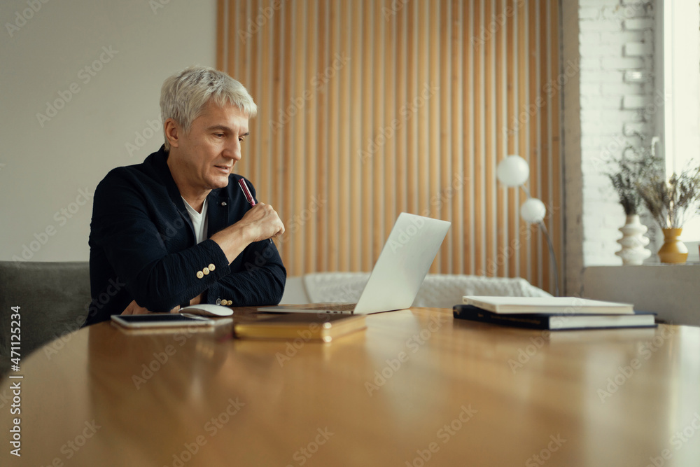 Financier message to client on laptop. The economist makes a company report. The agent creates projects online. An aged man works in the evening at the workplace. Financier message to client on laptop. The economist makes a company report. The agent creates projects online. An aged man works in the evening at the workplace.