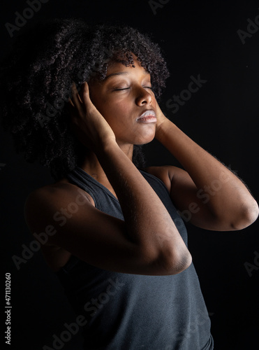 Afro woman lies relaxed in dark background se