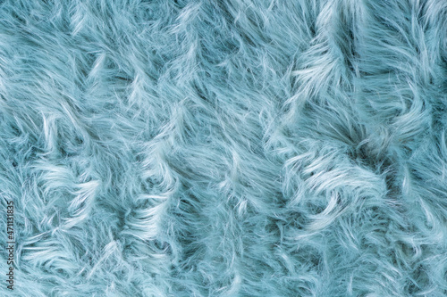 Trendy artificial fur texture. Fur pattern top view. Blue fur background. Texture of blue shaggy fur. Wool texture. Flaffy sheepskin close up
