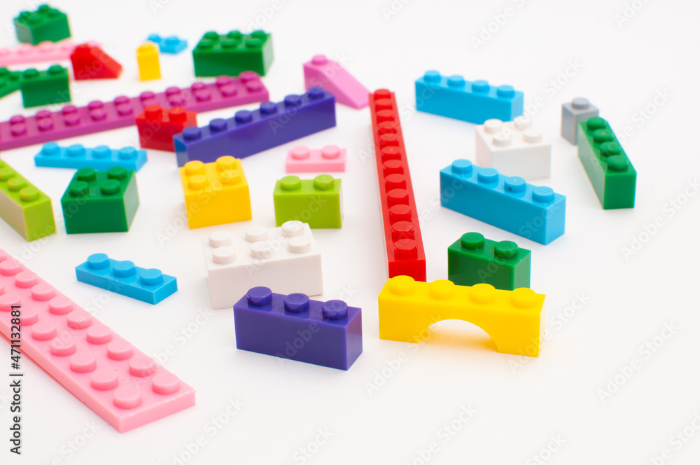Various details of a plastic constructor for children of various bright colors on a white background. Various details of a plastic constructor for children of various bright colors on a white background.