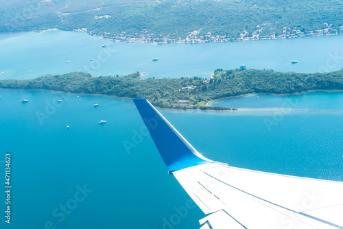 View of an airplane wing flying over the blue sea. Selective focus.