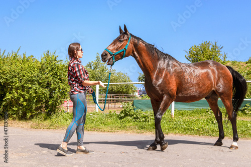 A young woman talks to a horse