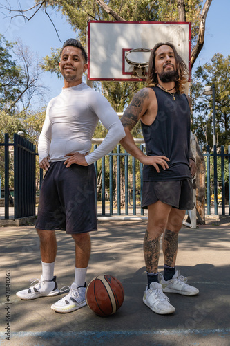 Retrato de dos jugadores latinos de baloncesto al terminar el partido
