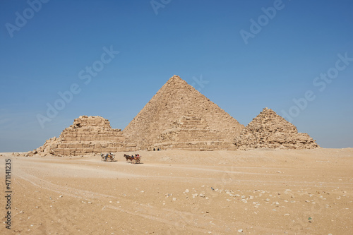 Horse drawn carts near Giza pyramids. Menkaure and pyramids Queens seen from desert