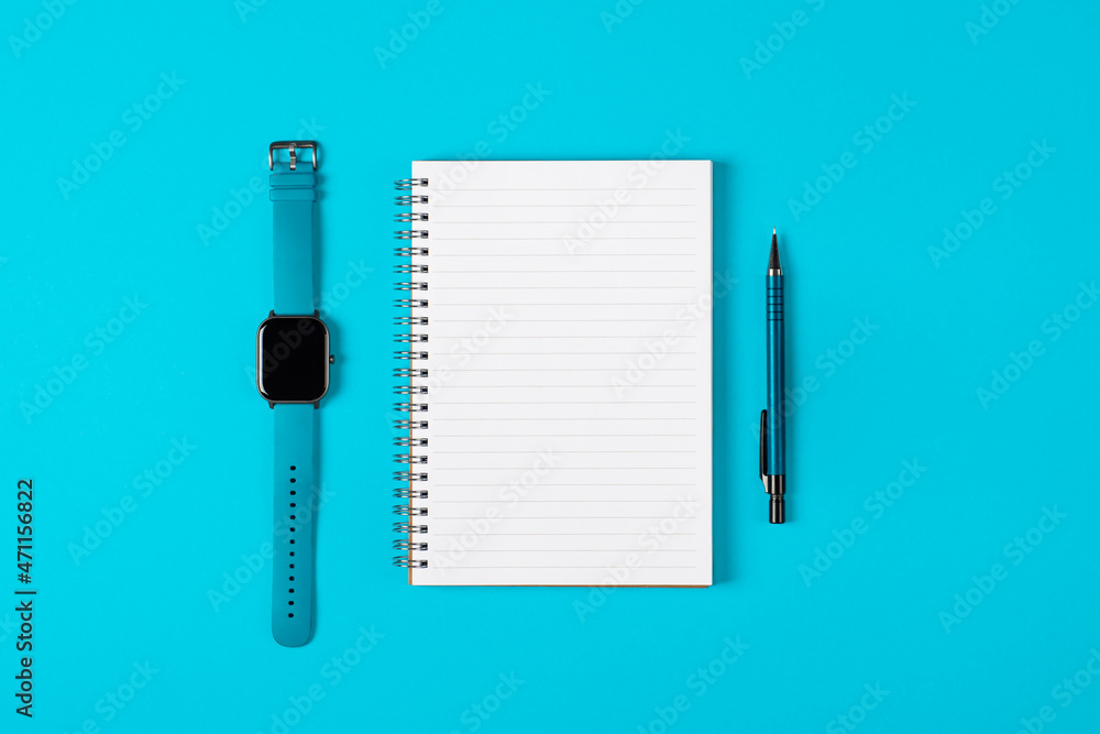 Notepad, watch, pen isolated on light blue background. Notepad with copy space. Office, business, discreet style Notepad, watch, pen isolated on light blue background. Notepad with copy space. Office, business, discreet style