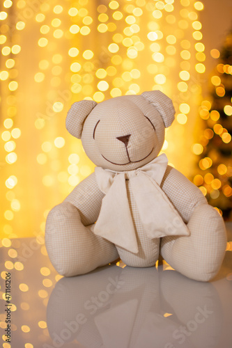 Ursinho de pelúcia, presente de natal, com um fundo iluminado photo