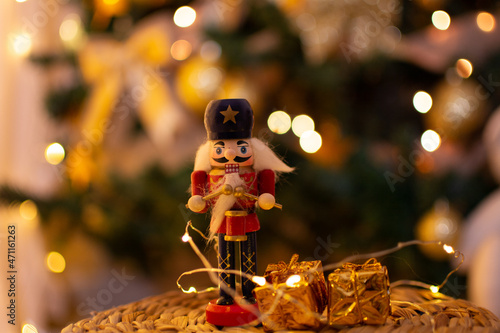 Wooden nutcracker soldier, Christmas tree ornament, with blurred tree in the background