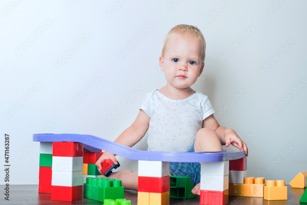 Toddler boy plays with constructor, cars, blocks close-up. Educational toys for preschool children... Toddler boy plays with constructor, cars, blocks close-up. Educational toys for preschool children...
