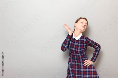 Shot of funny young blond woman making flirtatious grimaces and posing