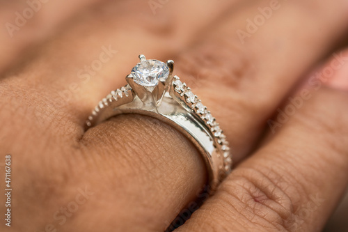 Close up view of a ring with diamonds in the finger of a woman