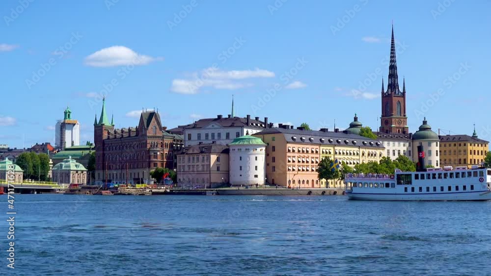 Stockholm, Sweden, 08.04.2021: Transport boat or ship runs between the islands on Lake Malaren. View Riddarholmen with towers and beautiful buildings. Famous landmarks of Sweden. Stockholm Panorama. Stockholm, Sweden, 08.04.2021: Transport boat or ship runs between the islands on Lake Malaren. View Riddarholmen with towers and beautiful buildings. Famous landmarks of Sweden. Stockholm Panorama.