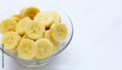 Banana slices in glass bowl on white  background.