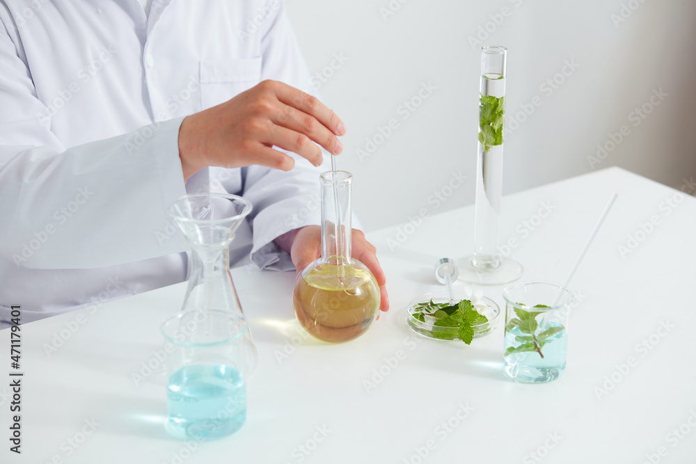 Plants extract in petri dish and a white background in laboratory , green leaf in a test tube and doctor for cosmetic advertising , photography science concept Plants extract in petri dish and a white background in laboratory , green leaf in a test tube and doctor for cosmetic advertising , photography science concept