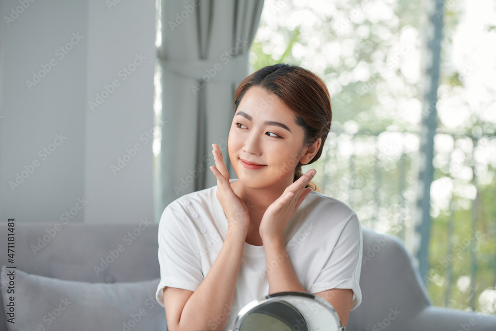 Happy young woman looking on mirror