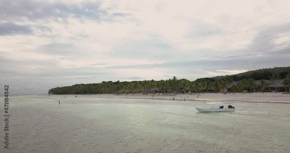 Panoramic View Of Tropical Beach With Tourist Boat Near The Shore On A Cloudy Day - aerial drone shot