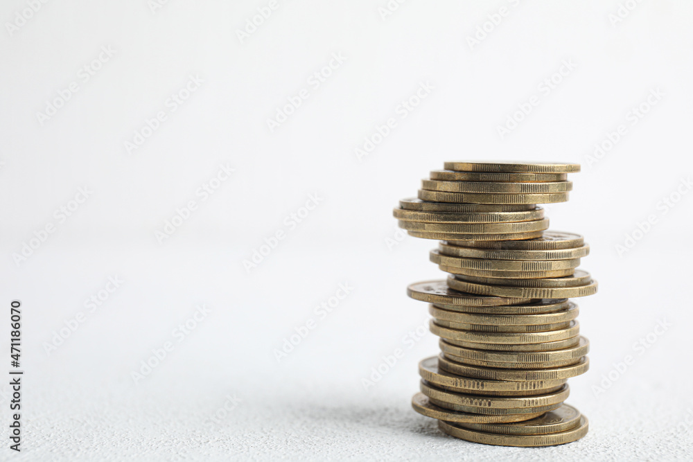 Many coins stacked on white table, space for text Many coins stacked on white table, space for text
