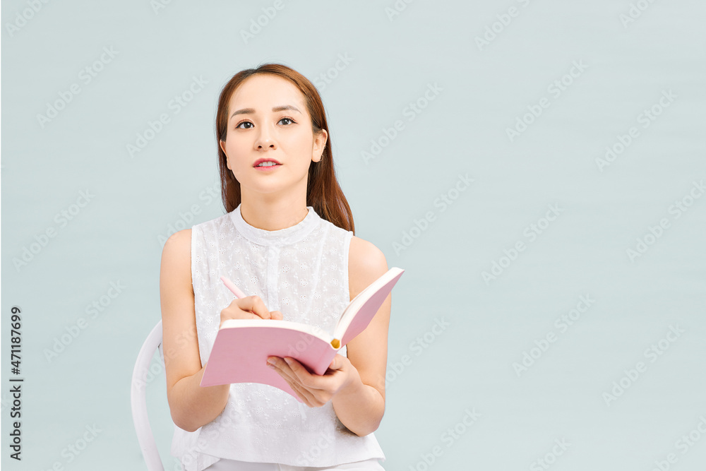 woman with diary and pencil sitting in chair