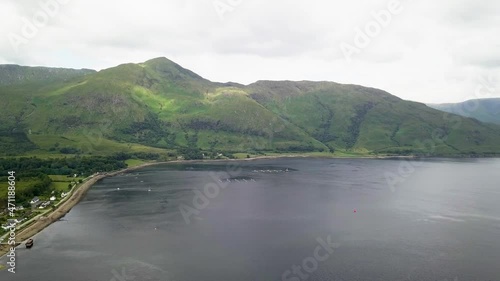 Aerial drone forward view of Sgurr Dhomnhuill mountain and fishing traps on lake water surface photo