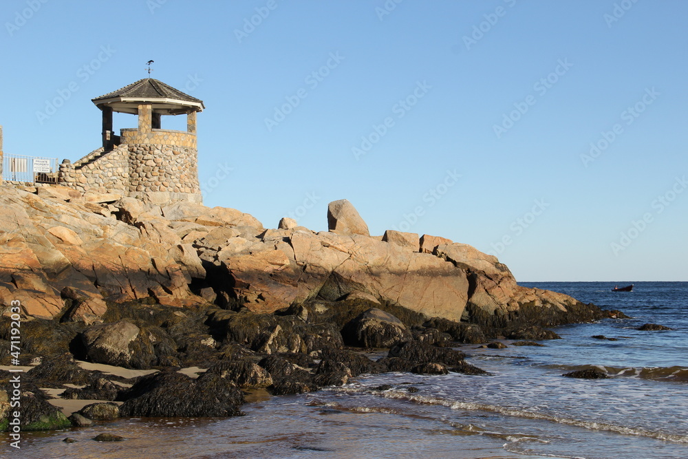 stone lighthouse on a rocky ocean beach