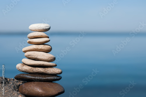Stack of stones on rock near sea  space for text. Harmony and balance concept