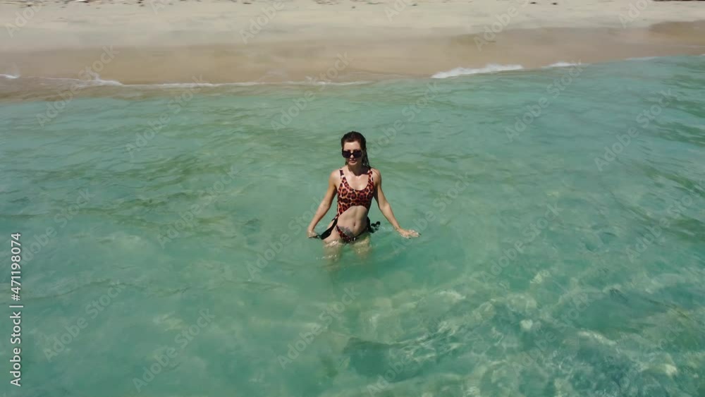 Drone flying around sexy woman in leopard swimsuit in ocean in Nusa Penida Bali Indonesia . High quality aerial 4k footage Drone flying around sexy woman in leopard swimsuit in ocean in Nusa Penida Bali Indonesia . High quality aerial 4k footage