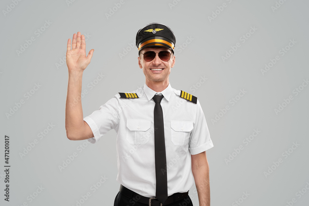 Smiling aviator waving hand in studio Smiling aviator waving hand in studio