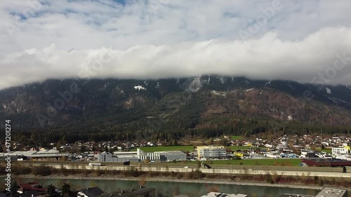 Drone flies up over Brixlegg in Tyrol, mountains with clouds and the river Inn photo