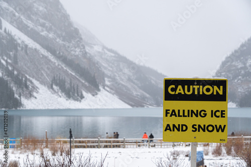 Falling Ice and Snow warning sign in national park during snowfall
