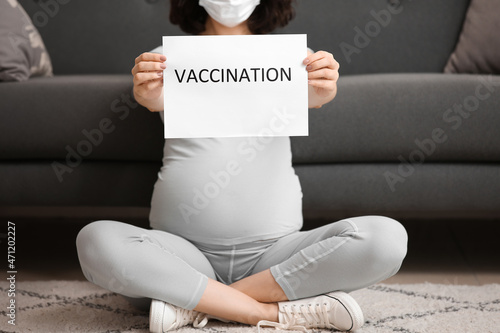 Young pregnant woman holdin...