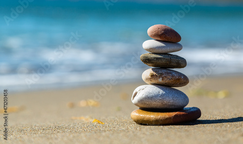 Pyramid stones balance on the sand of the beach. The object is in focus, the background is blurred. Yesilovacik,Mersin,Turkey.