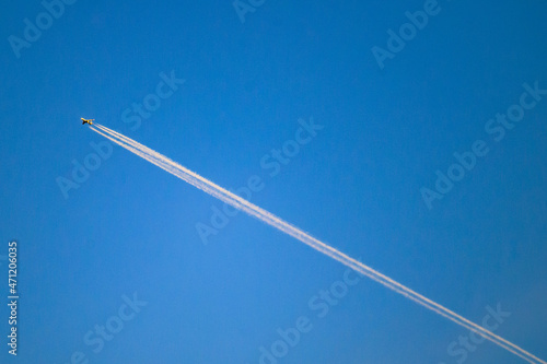 jet airplane with contrail in the blue sky