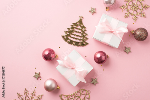 Top view photo of row composition christmas decorations pink balls gold bell pine snowflake shaped ornaments stars white gift boxes with pink bows and sequins on isolated pastel pink background