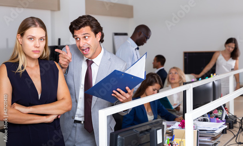Canvas Print Male angry boss blaming young woman office worker in office
