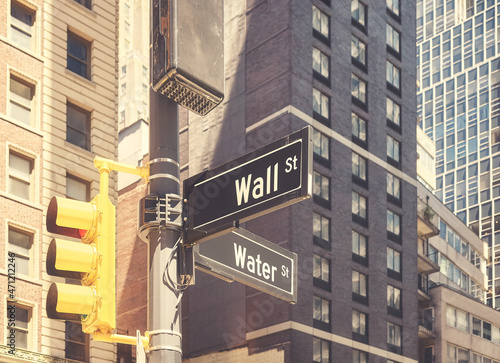 Traffic lights pole with Wall Street and Water Street in downtown New York, color toning applied, USA.