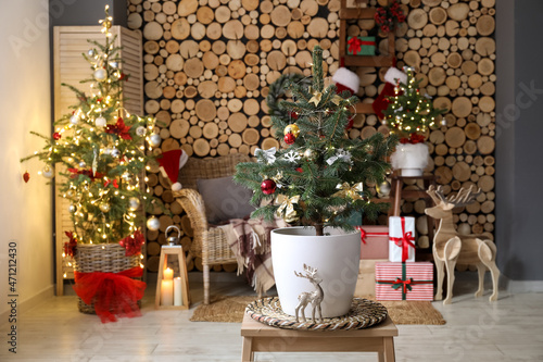 Small Christmas tree with glowing lights on table in living room