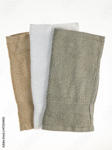 three napkins towels of different colors of the same size on a white background