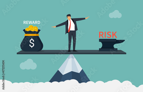 Businessman balancing between reward and risk business concept on top of mountain.