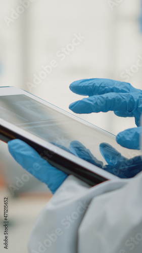 Close up of hand using dental x ray on modern tablet at oral clinic cabinet. Stomatology assistant holding device with radiography and scan technology examining teeth model for patient