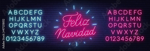 Feliz Navidad neon text. Greeting card on brick wall background.