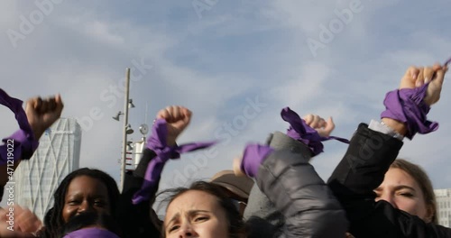 group of women with raised fists shouting slogans in feminist protest photo
