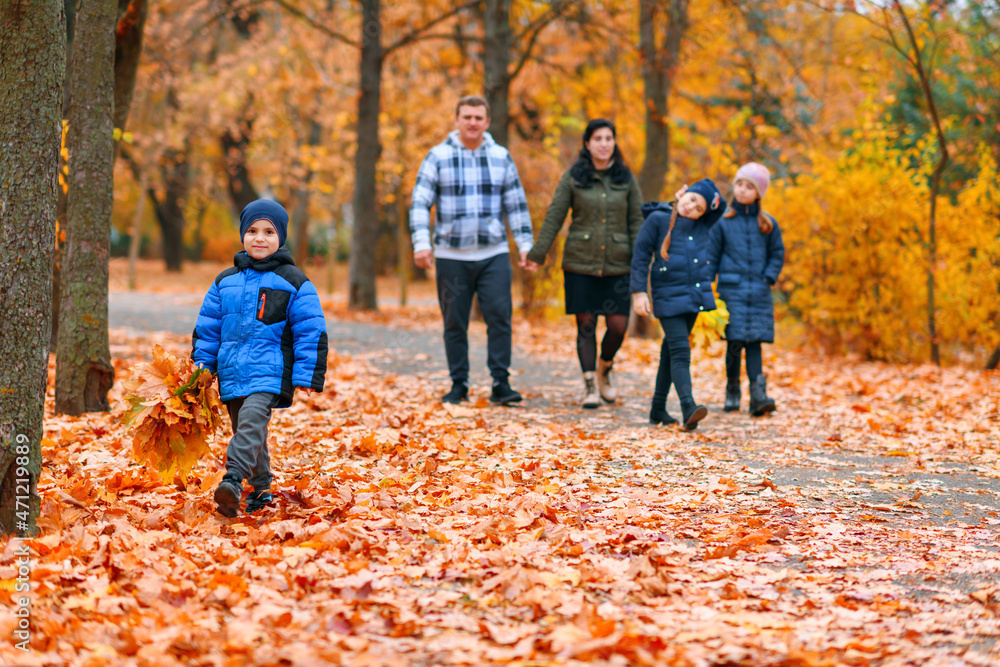 Portrait of a family with children in an autumn city park - happy people walking together, beautiful nature with yellow leaves as background. Portrait of a family with children in an autumn city park - happy people walking together, beautiful nature with yellow leaves as background.